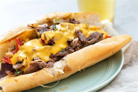  Philly Cheesesteak: Uma Sinfonia De Queijo Derretido E Carne suculenta em um Pão Crocante!